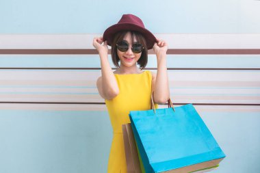 Sarı elbiseli ve güneş gözlüklü Asyalı güzel bir kızın portresi..