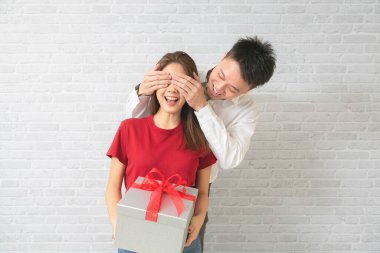 Tuvalette ona sürpriz yapmak için kız arkadaşının gözlerini kapatan genç bir adamın görüntüsü..