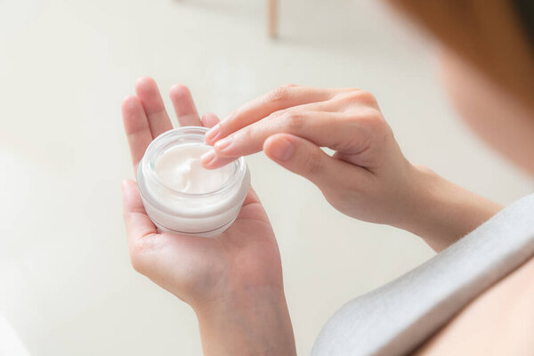 Closeup of hands applying moisturizer. Beauty woman holding care cream of skin cream.