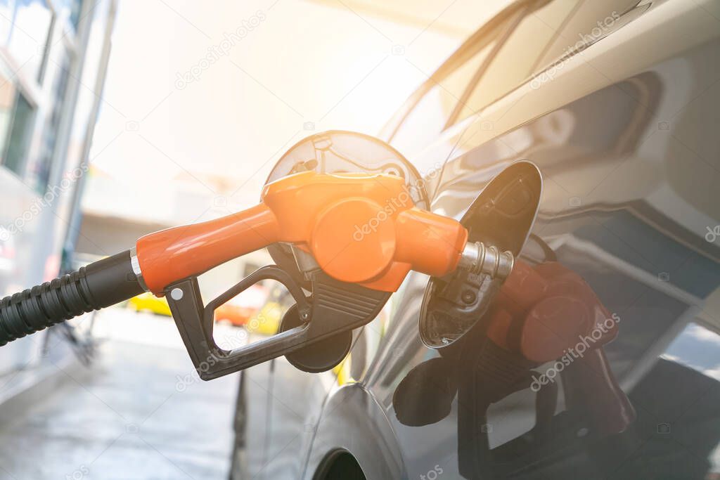Man pumping gasoline fuel in car at gas station. Transportation and ownership concept.