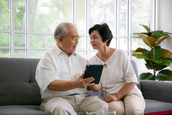 Couple Seniors Smiling Looking Same Tablet Sofa Mature Couple Making — Stock Photo, Image