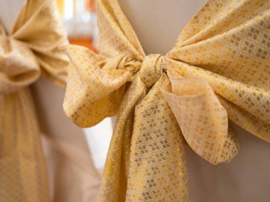 düğün töreninde sarı altın yay süslenmiş düğün koltukları.