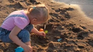Sahilde oynayan üç yaşındaki kız. Denizde aile tatillerinde çocuk