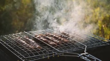 Küçük bir barbekü ızgara üzerinde sauages yakın.