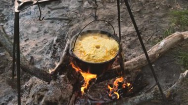 Dökme demir kazanda açık havada yemek. Bir ateş üzerinde pişirme et. Yiyecek bir kazan bir yanıyor. Yemek yemek kazanı olarak doğada.
