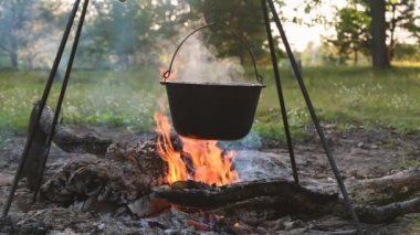 Dökme demir kazanda açık havada yemek. Bir ateş üzerinde pişirme et. Yiyecek bir kazan bir yanıyor. Yemek yemek kazanı olarak doğada.