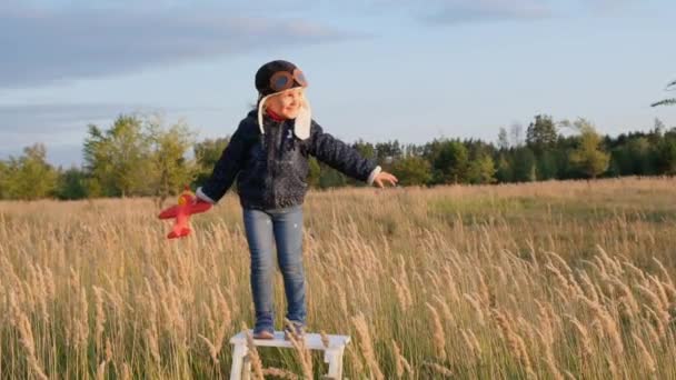 Glückliches Kind Spielt Mit Spielzeugflugzeug Vor Herbstlichem Himmel Bei Sonnenuntergang — Stockvideo