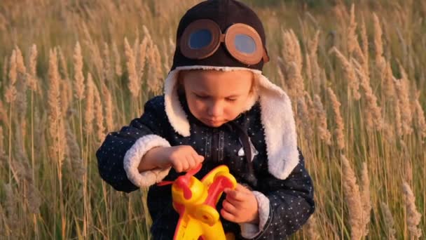 日没時の秋の空の背景におもちゃの飛行機で遊ぶ幸せな子供 — ストック動画