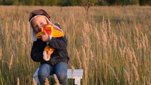 日没時の秋の空の背景におもちゃの飛行機で遊ぶ幸せな子供 — ストック動画