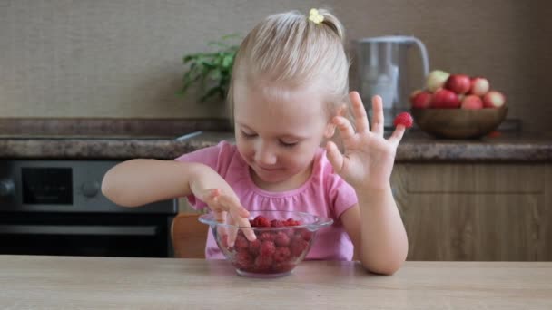 かわいい小さな女の子の肖像画面白い食べる赤いラズベリーは 指に置かれた — ストック動画