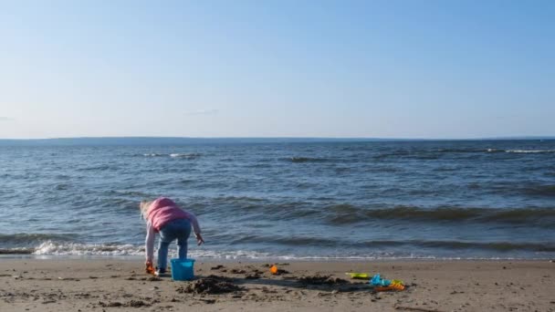 슬로우 모션에서 해변을 귀여운 해변을 소녀는 천천히 해변에서 있습니다 해변에서 — 비디오