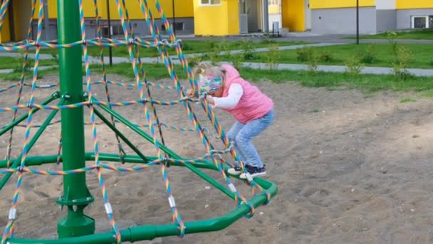 遊び場で遊んで幸せな女の子は 楽しみを持っています スローモーション 喜びに満ちたアクティブな子供時代 — ストック動画