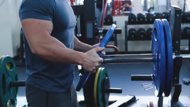 Close Hands Bodybuilder Puts Additional Weights Barbell Muscular Fit People — Stock Video