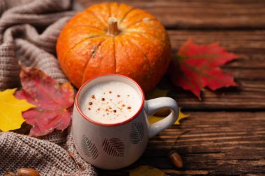 Kabak baharatlı latte veya kahve cam turkuaz vintage arka plan üzerinde örme eşarp süslenmiş. Sonbahar, sonbahar veya kış sıcak içecek. Rahat kahvaltı.