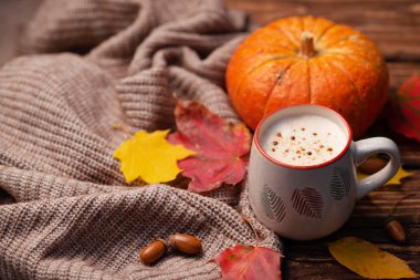Kabak baharatlı latte veya kahve cam turkuaz vintage arka plan üzerinde örme eşarp süslenmiş. Sonbahar, sonbahar veya kış sıcak içecek. Rahat kahvaltı.