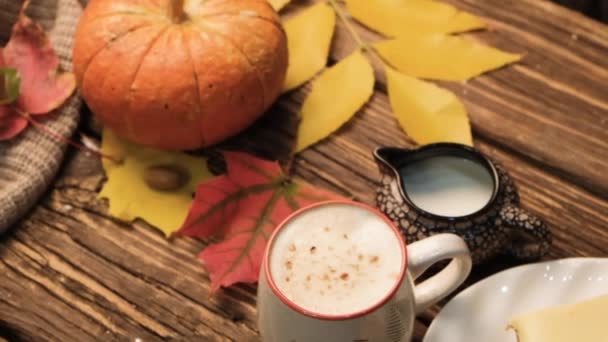 Autumn composition with cappuccino, carrot cake, pumpkin and leaves on an old wooden table. Autumn concept. — Stock Video