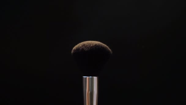 Dos pinceles de maquillaje negro con polvo o rubor sobre un fondo oscuro. Concepto de belleza — Vídeo de stock