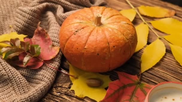 Autumn composition with cappuccino, carrot cake, pumpkin and leaves on an old wooden table. Autumn concept. — Stockvideo