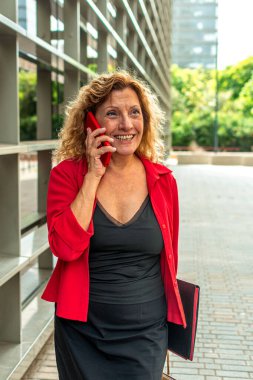 Ofis binalarının yanında elinde dosyayla sohbet ederken ve güzel sohbetlerin keyfini çıkarırken mutlu kıdemli yönetici.