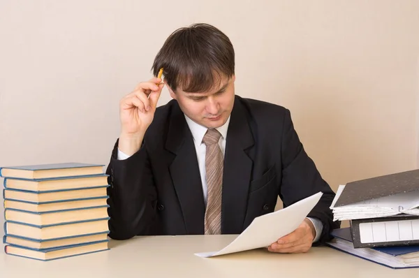 Der Mitarbeiter dachte über das Dokument am Tisch im Büro nach — Stockfoto