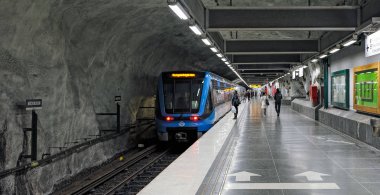 Stockholm, İsveç - 7 Mayıs 2017: Mavi metro tren istasyonu platformu Stockholm metro sisteminde nerede tren için bekleyen bir adam gelir.