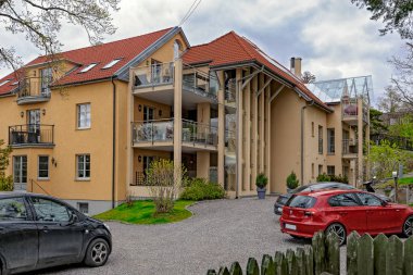 Lidingo, İsveç - 08 Mayıs 2017: Çağdaş modern görünümlü apartmanın turuncu bir güneşli bahar gününde detayları ile.
