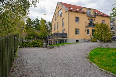 Lidingo, İsveç - 08 Mayıs 2017: Çağdaş modern görünümlü apartmanın turuncu bir güneşli bahar gününde detayları ile.