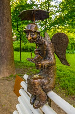 ST.PETERSBURG, RUSSIA -June 19, 2017: Angel Of Saint-Petersburg micro sculpture on the bench in the Izmaylovsky Garden. clipart