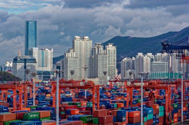 Busan, Güney Kore - 22 Aralık 2016: Sunrise panorama konteyner kargo terminali bağlantı noktası Busan, Kore'nın en yoğun ve tüm 10-yoğun multistorey konut önünde Dünya.