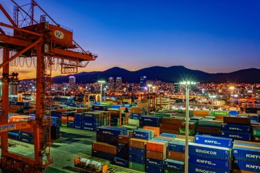 BUSAN, SOUTH KOREA - Jan 21, 2017: Night wide angle panorama of cargo vessel in the port of Busan, South Korea, the fifth largest container terminal harbor in the world. clipart