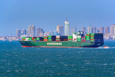 Qingdao, Çin - 20 Ocak 2017: bir liman pilot yüklü konteyner gemisi hiç Unific önünde Jiaozhou Körfezi kıyı Evergreen nakliye şirketi tarafından sunulan Pilot tekne.