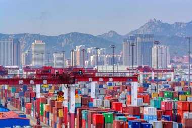Qingdao, Çin - 15 Mayıs 2017: Qianwan konteyner terminali Qingdao, arka planda şehir manzarası ile.