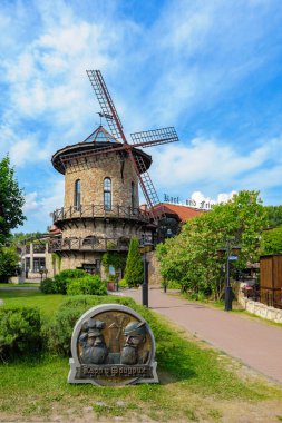 ST. PETERSBURG, RUSSIA - Jun 18, 2018: Restaurant-brewhouse in Bavarian style with replica of windmill and old building in Primorsky Victory Park, Krestovsky Island. clipart