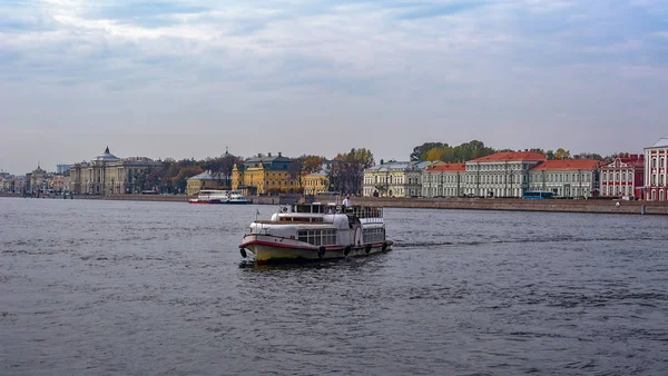 Sightseeing boat in front of buildings along the University embankment. Saint-Petersburg, Russia. — Stock Photo, Image