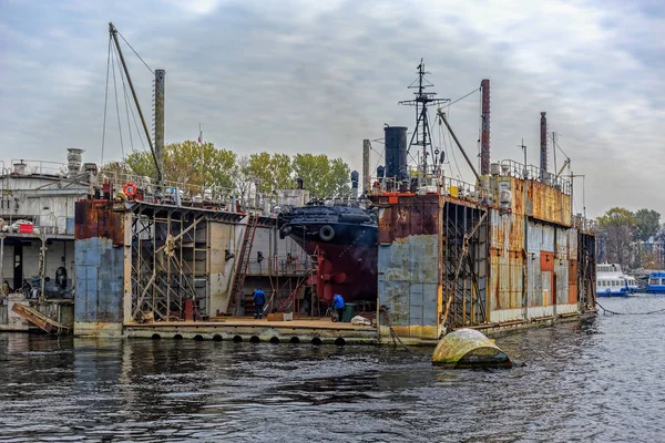 Tug boat under repair at floating dry dock in shipyard. — Stock Photo, Image