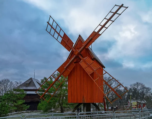 Starý červený okre dřevěný větrný mlýn v zimě ve Skansen — Stock fotografie