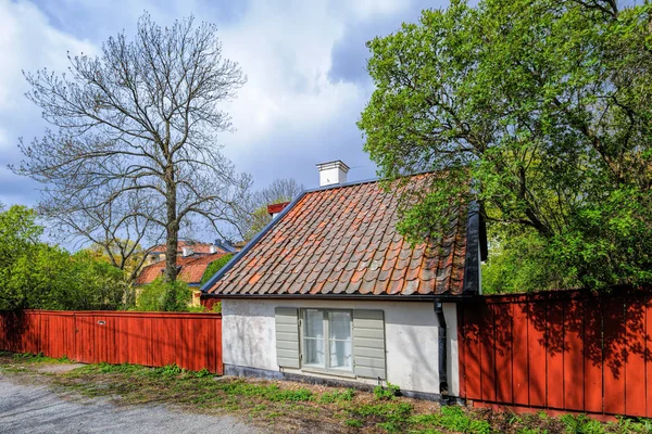 Typický švédský obytný dům s dřevěným plotem namalovaným v tradiční Falunu v kulturní rezervaci Vita Bergen (White Hill) ve Stockholmu. — Stock fotografie