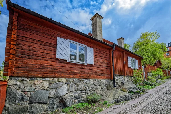 Smal kullerstensbelagd gata i ett historiskt område på Asoberget med ett trähus målat i traditionell Falun röd. — Stockfoto