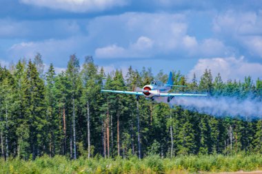 İki koltuklu tek motorlu pistonlu Yakovlev Yak-52 birincil akrobasi eğitmen uçağı Oh-Yac Karhula havacılık müzesi airshow akrobasi gerçekleştirir. Kotka, Finlandiya.