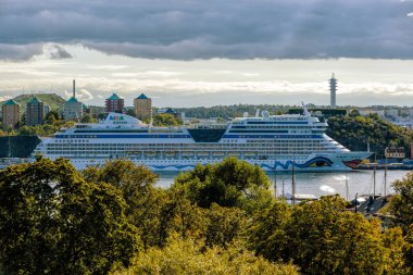 Sfenks sınıfı yolcu gemisi Aidamar (2012) güneşli sonbahar gününde Sodermalm adasındaki iskelede Aida Cruises tarafından işletilmektedir..