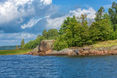Adanın çok tonluk devasa kayaları (düzensiz bloklar) olan kayalık bir sahili. Finlandiya Körfezi 'nde Baltık temel kristal oluşumlar ve buzul manzaraları (sürüklenme çağı).