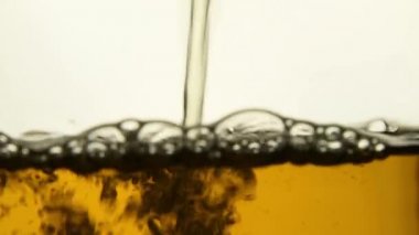 Stream sıcak oolong yeşil çay şeffaf cam çaydanlık, hava kabarcıkları akımı ve su seviyesi artar, ağır çekim, düşük açılı yan görünümü kadar aşırı yakın doldururken döktü