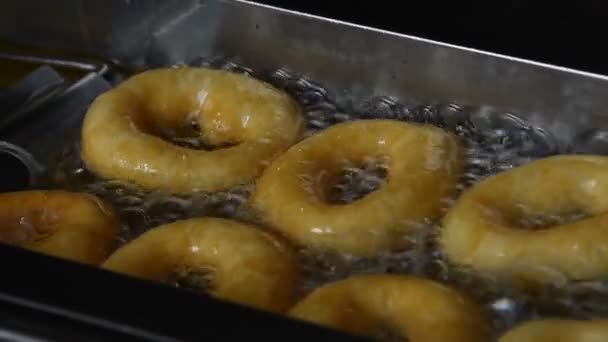 Close Deep Frying Several Small Ring Donuts Sizzling Oil High — Stock Video