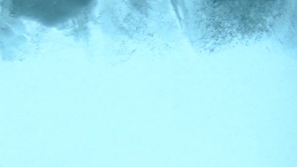 Klare Eiswürfel Mit Luftblasen Schwimmen Drehen Wirbeln Und Schmelzen Blauem — Stockvideo