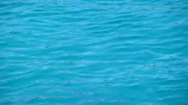 Su yüzeyinde, yüksek açılı görünüş çalışan canlı Camgöbeği mavi deniz arka plan yakından dalgaların