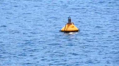 Mavi deniz su dalgaları ve dalgaların içinde yüzen sarı şamandıra kapatın