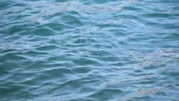 近距离背景的蓝色海浪和波纹与明亮的耀斑闪烁在水面上运行 — 图库视频影像