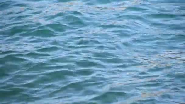 Gros plan arrière-plan des vagues et des ondulations de la mer bleue avec des éclats lumineux qui coulent à la surface de l'eau 