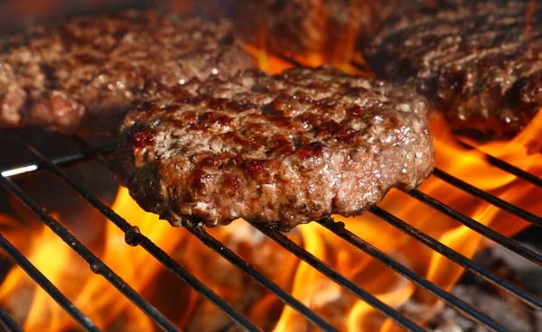Biftek ya da domuz eti barbeküsü hamburgerleri BBC alev ızgarasında kızartılmış, yüksek açı manzaralı.