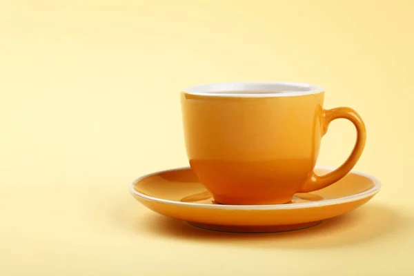 パステル カラー紙の背景 低角度側ビューをかけて つの完全黄色カップ ソーサーにコーヒー 紅茶メーカーを閉める — ストック写真